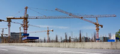 Construction site with cranes against blue sky
