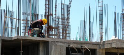 Man kneeling on unfinished building during daytime